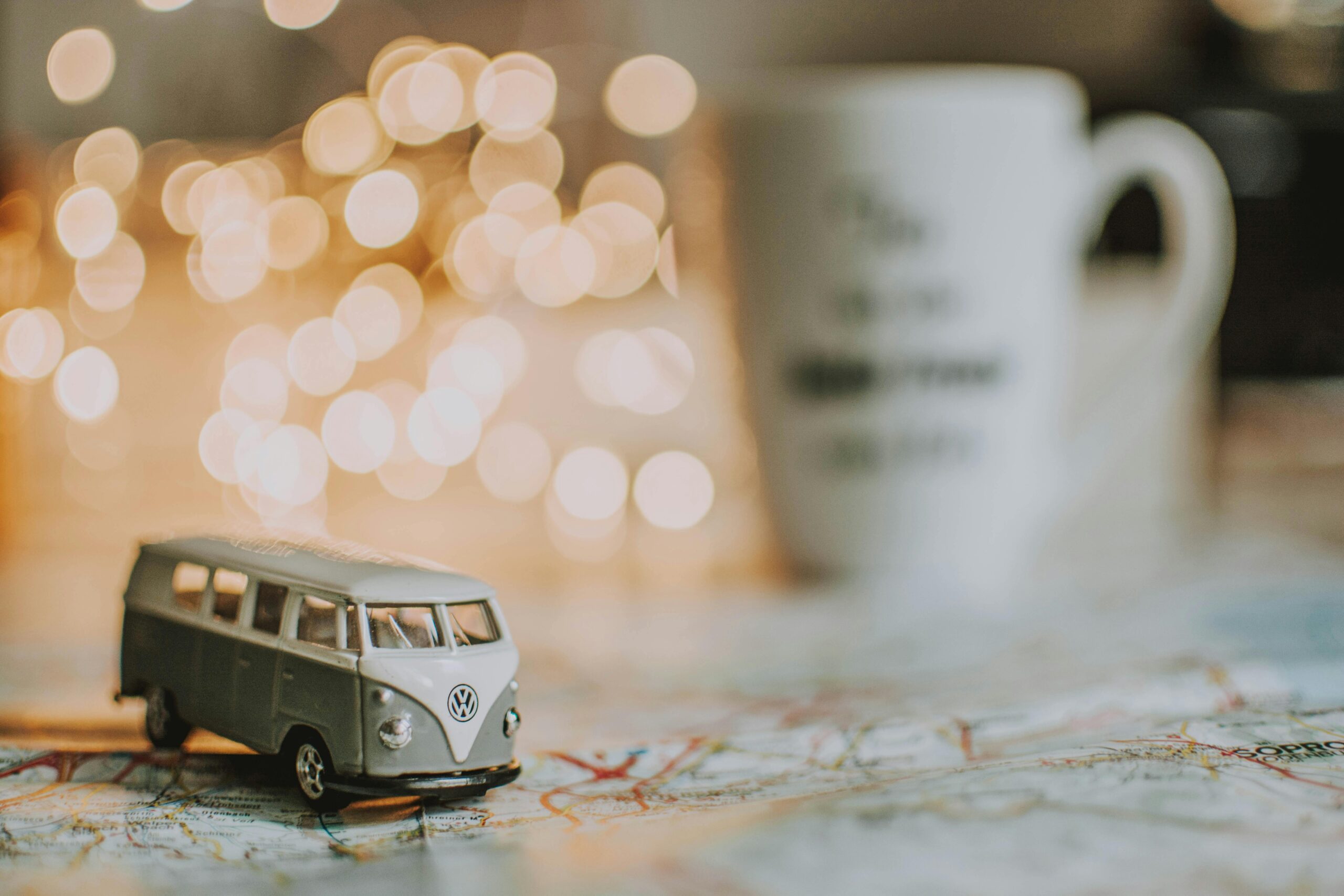 toy camper van on map next to cup of tea